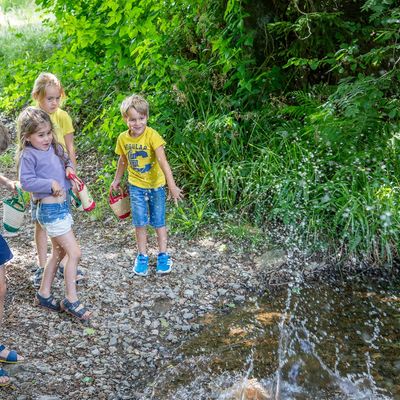 Des enfants lancent des cailloux dans le ruisseau près de l'école
