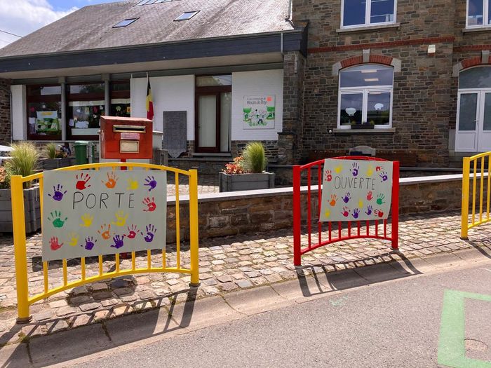 Banderoles « Porte ouverte » décorées d'empreintes de mains colorées sur les barrières de l'école
